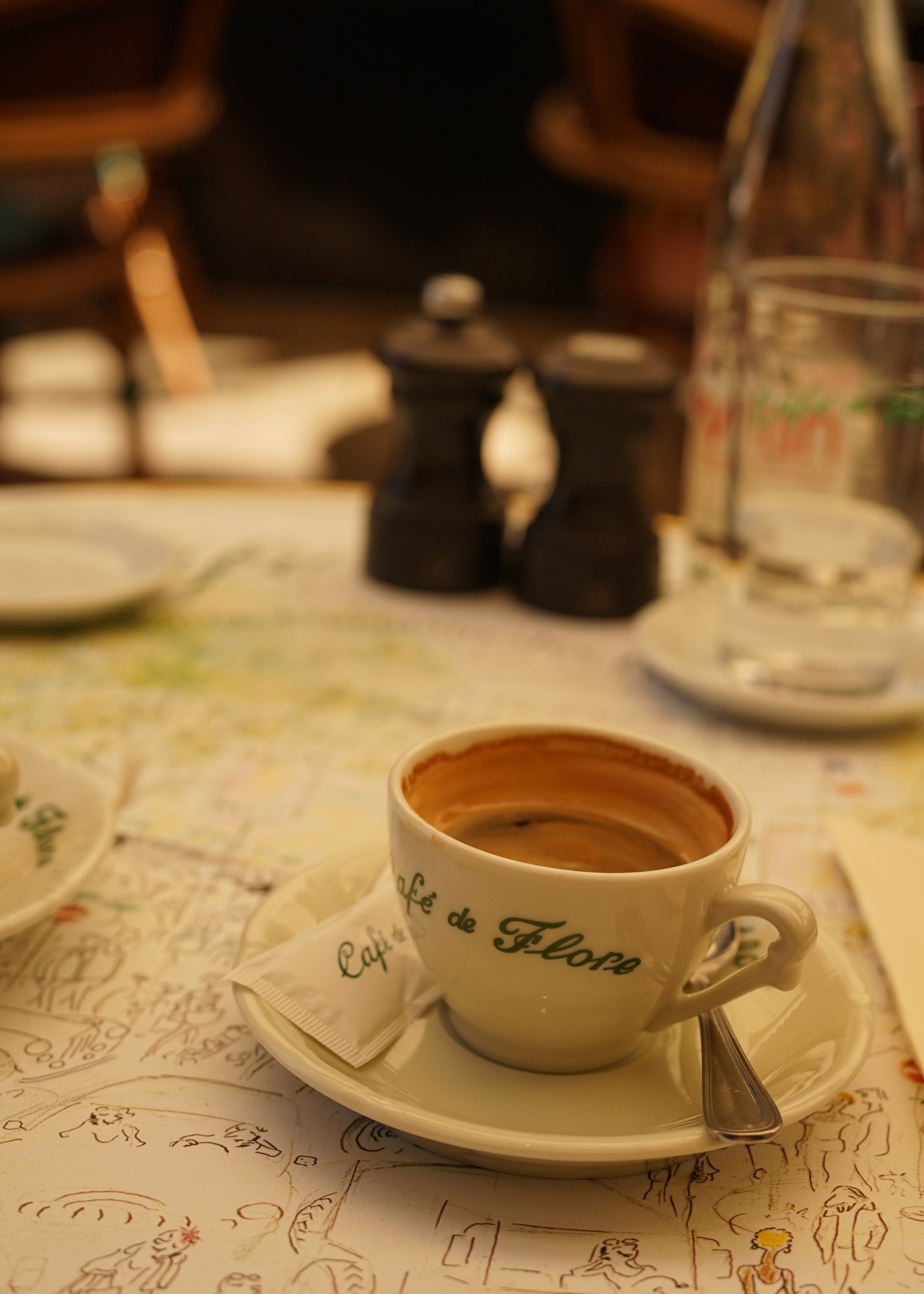 Café de Flore cup on a table with a patterned tablecloth