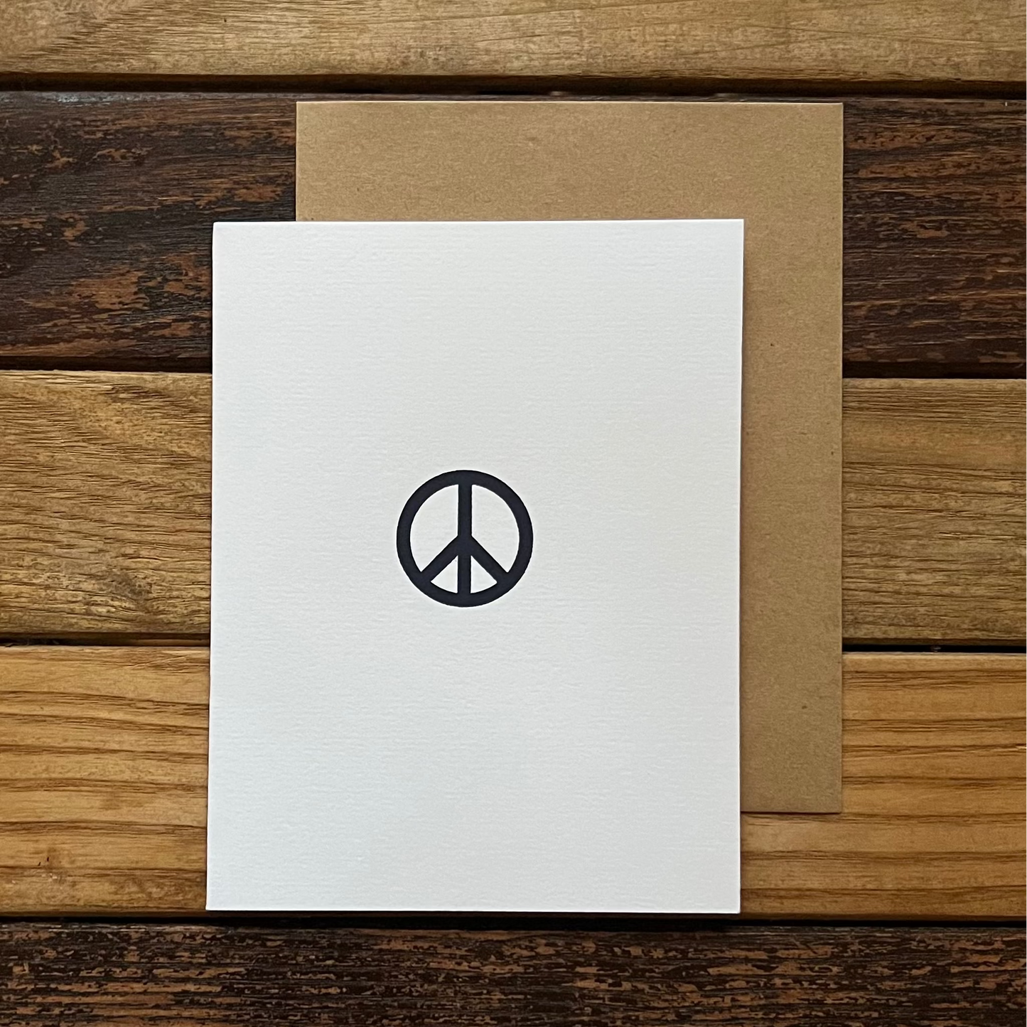 White card with peace symbol on a wooden surface