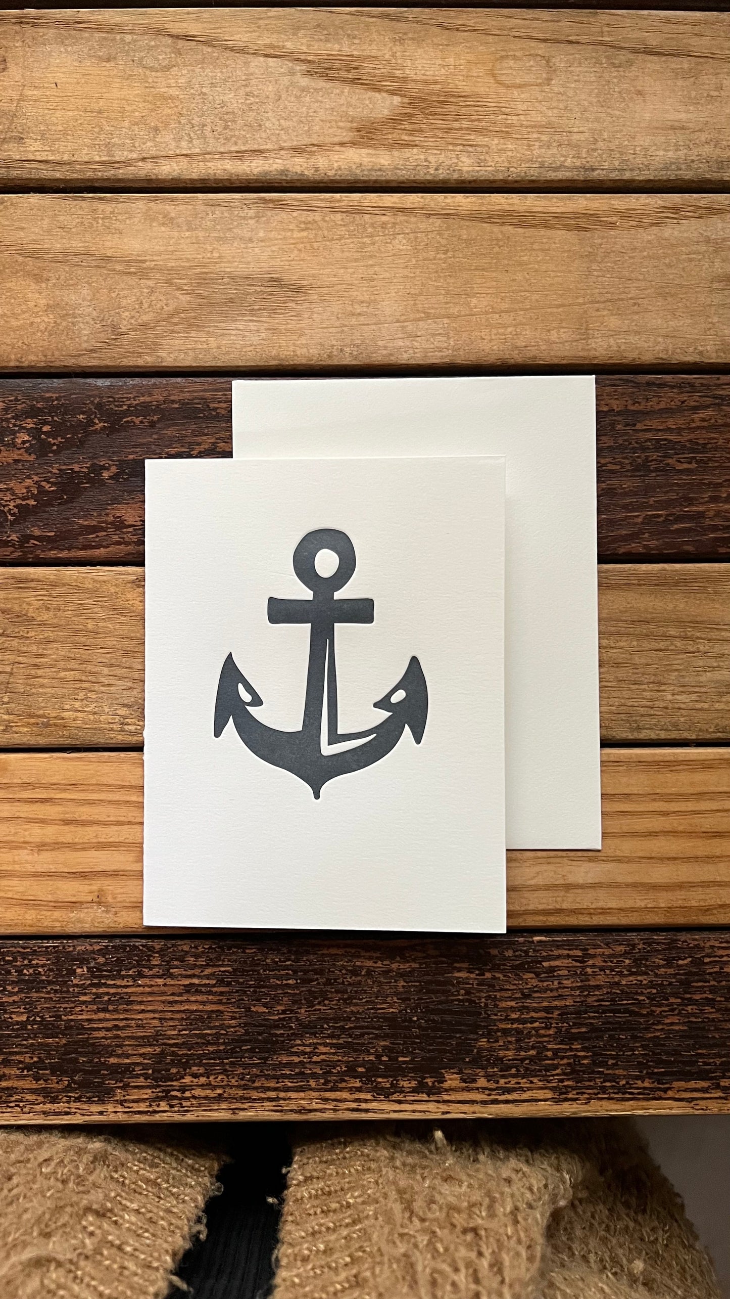 Note card with anchor design on a wooden surface