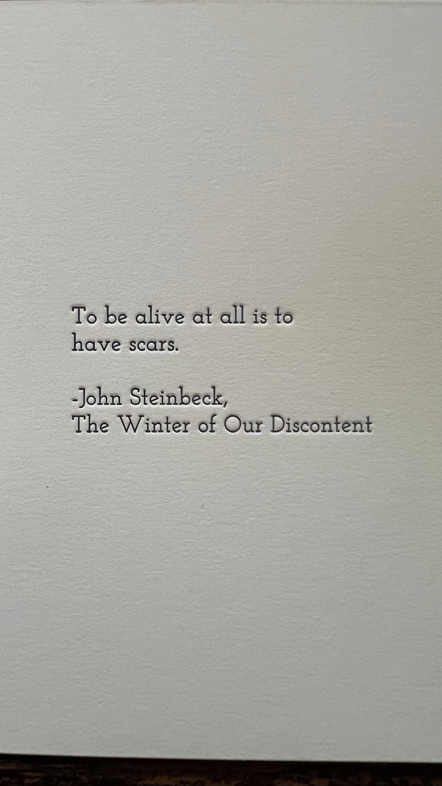 Text quote by John Steinbeck on a textured gray background