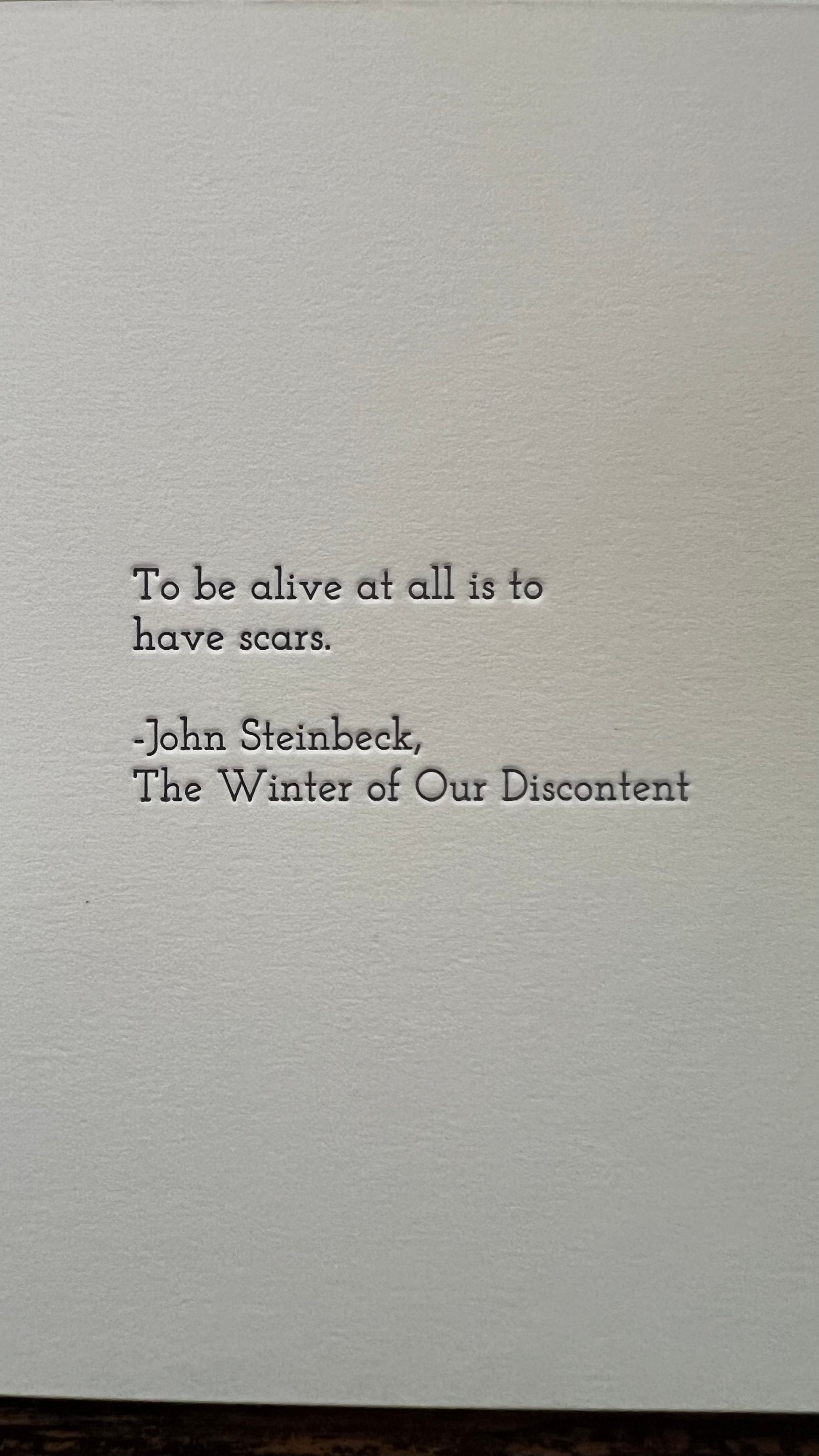 Text quote by John Steinbeck on a textured gray background