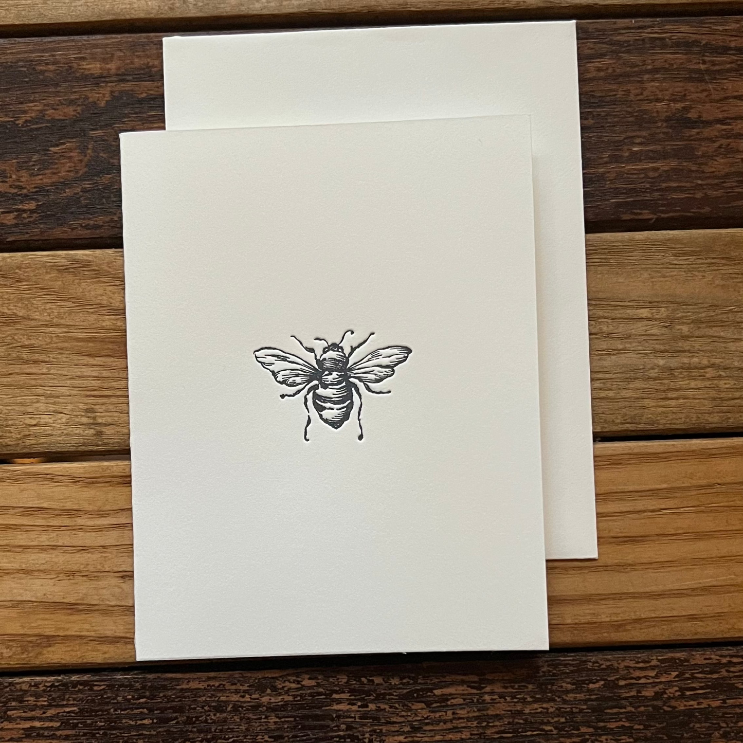 Card with a bee design on a wooden surface