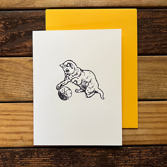 Greeting card with bear illustration on white paper, yellow envelope on wooden surface