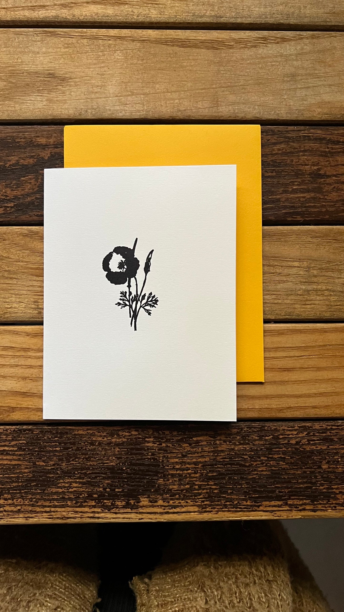 White card with black floral design on a wooden surface