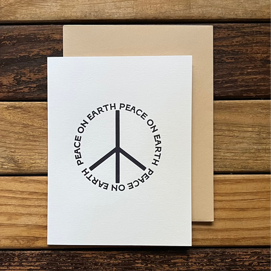 Greeting card with peace symbol design on a wooden surface