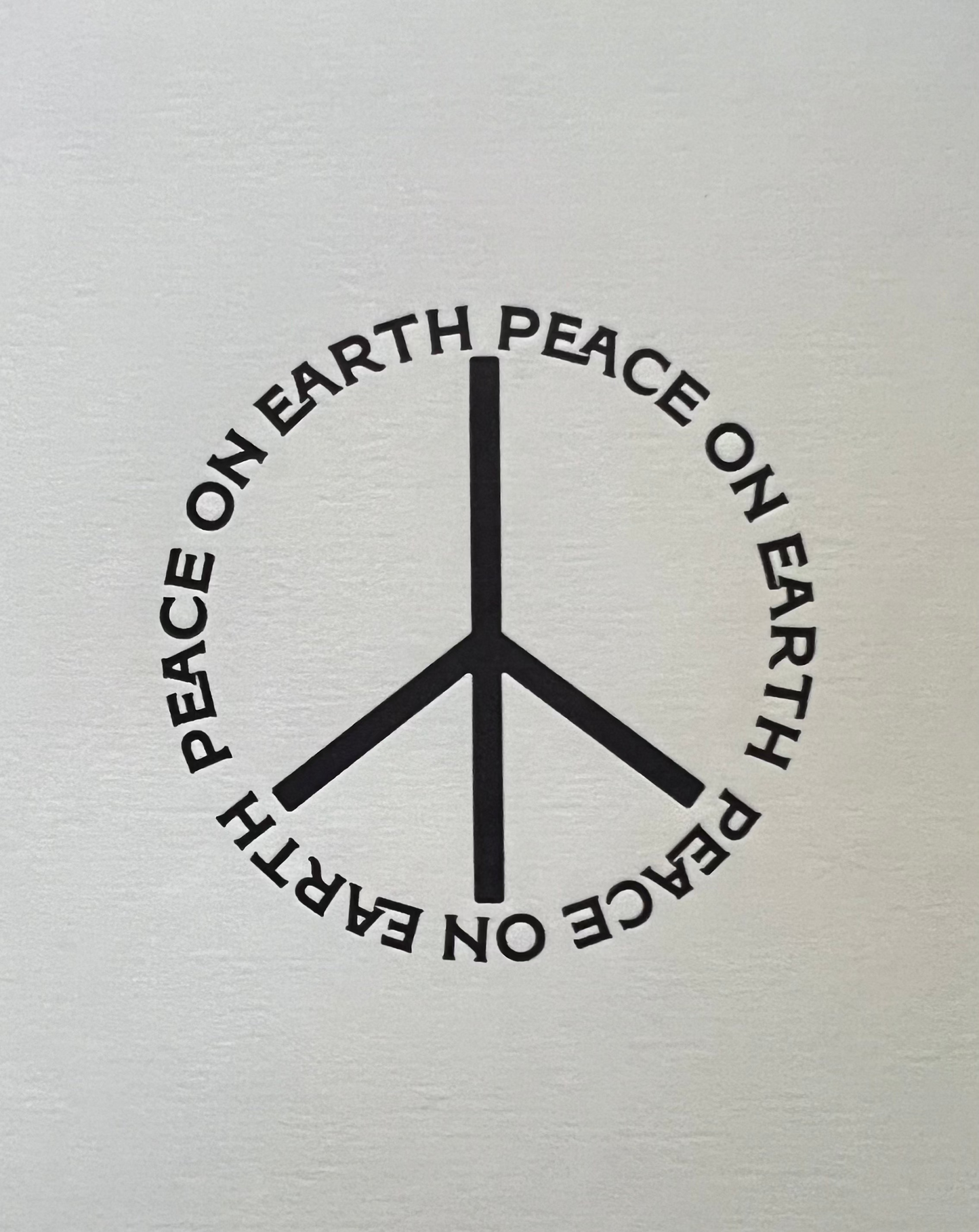 Peace symbol with 'Peace on Earth' text on a white background