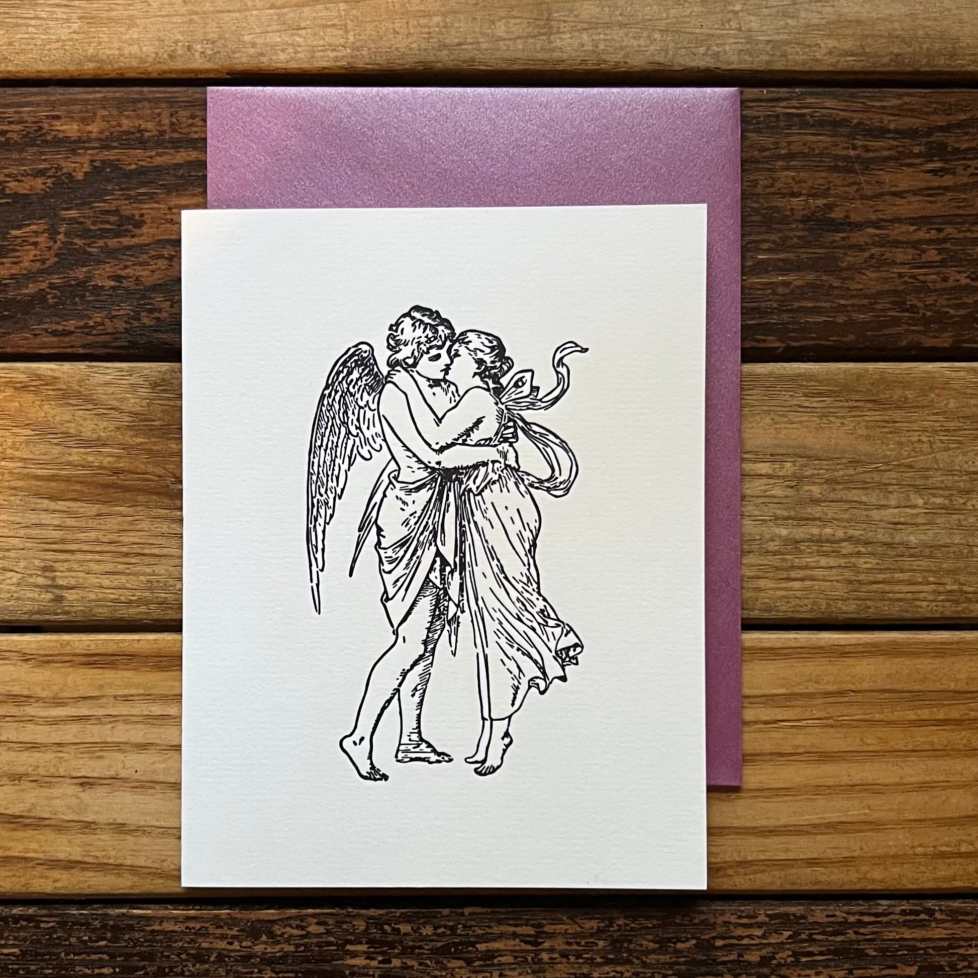 Greeting card with angel and woman illustration on a wooden surface