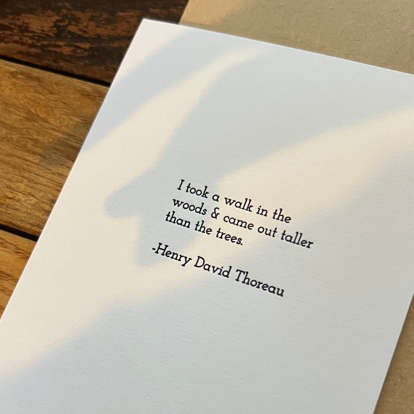 Note with a quote by Henry David Thoreau on a wooden surface