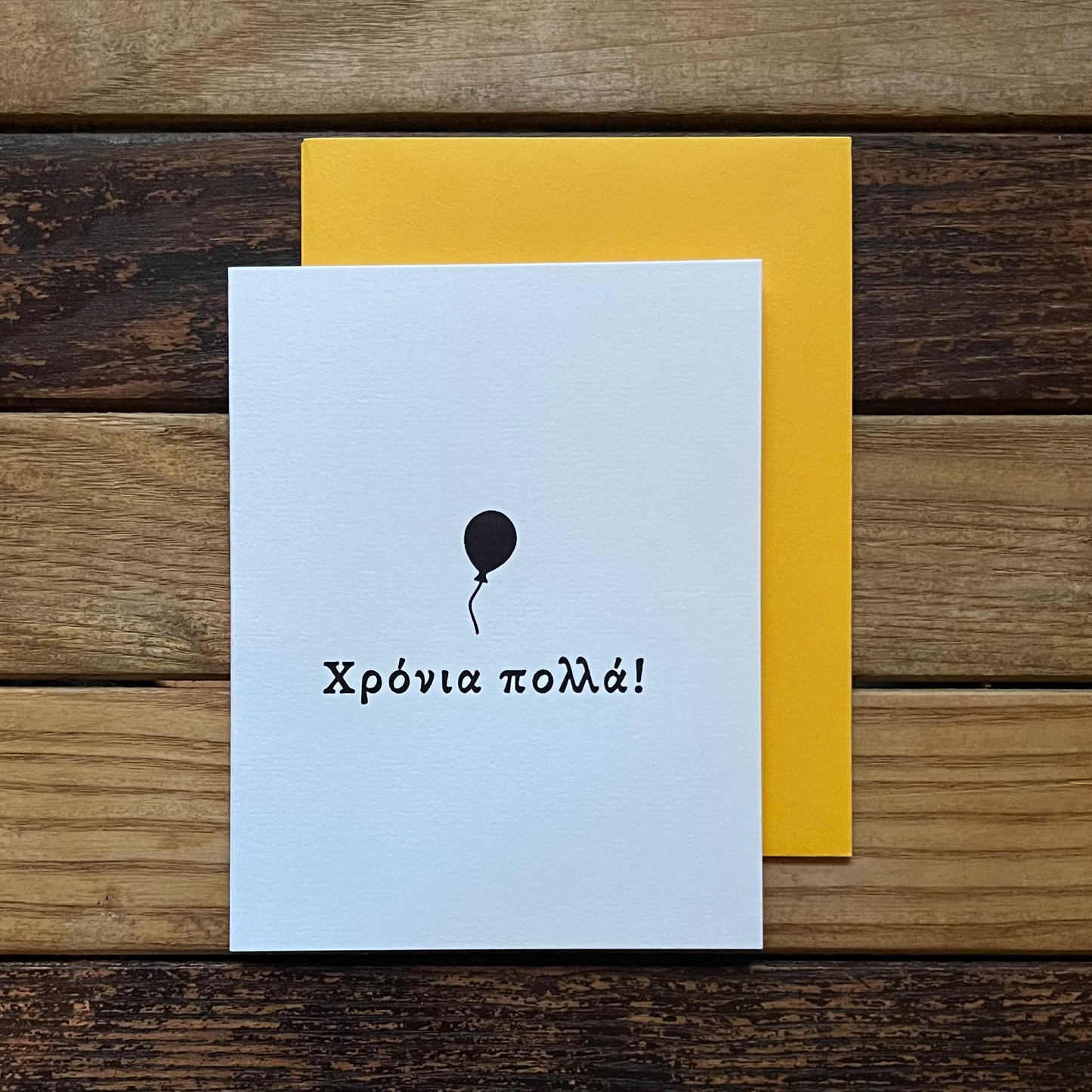 Greeting card with a balloon and text on a wooden surface
